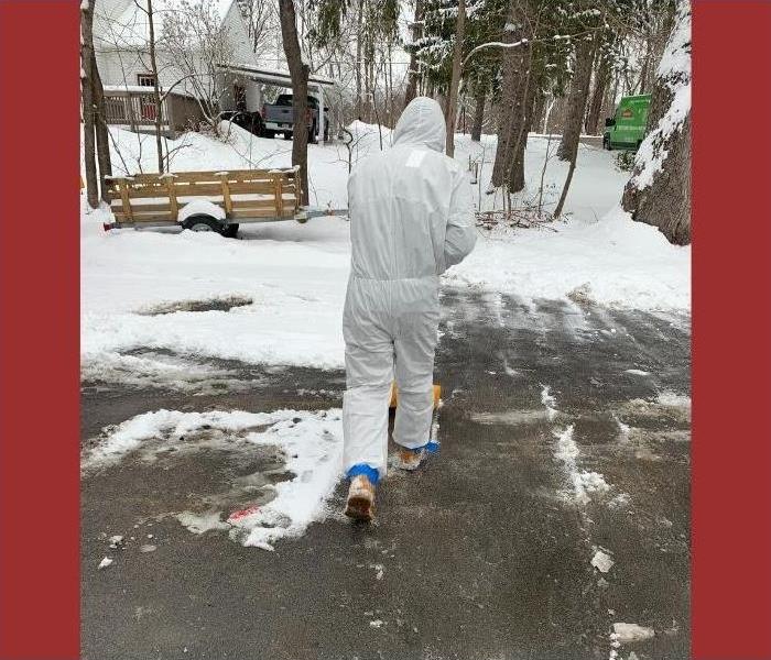 Our SERVPRO technician shoveling snow in a hazmat suit.