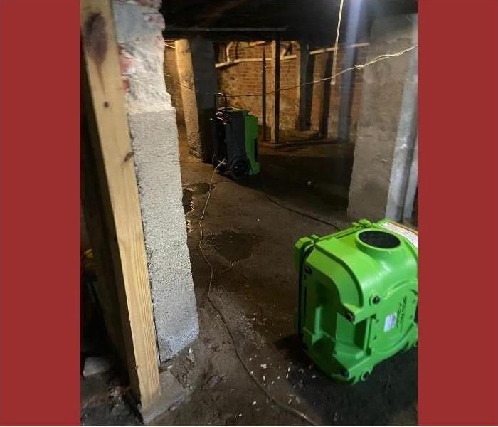 Drying out the basement using powerful pumps and vacuums.