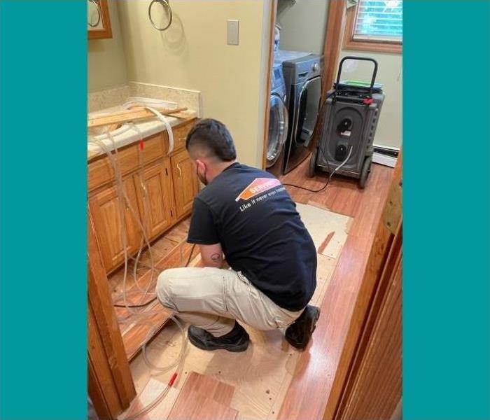 One of our certified technicians pulling up the floorboards to access the water damage underneath.