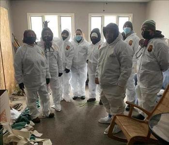 A group of our SERVPRO employees wearing hazmat suits at a job site.