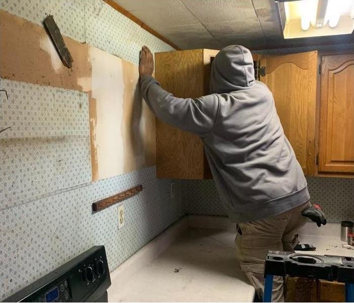 One of our SERVPRO technicians removing kitchen cabinets due to water damage.