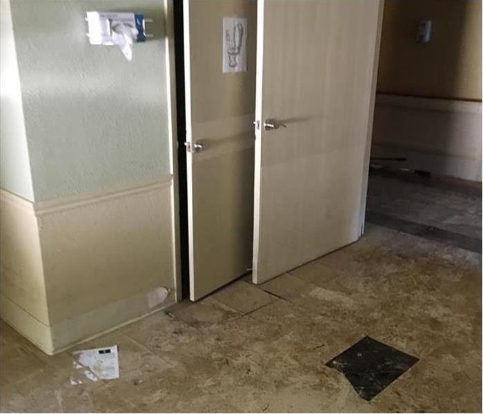 The doorway to an office with water damaged tiles from a bad storm.