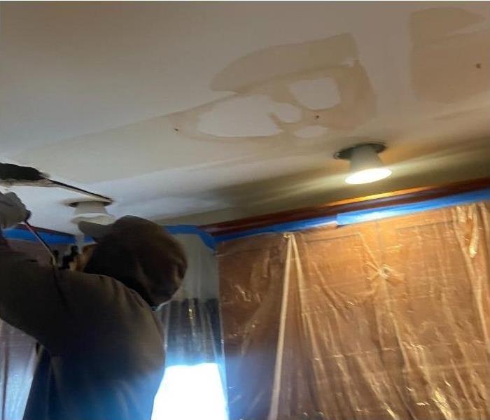 A SERVPRO technician working on water damage in the ceiling of a Saratoga home.
