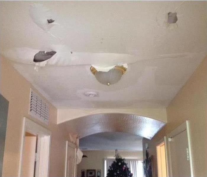 A water damaged ceiling with paint bubbles and peeling paint.