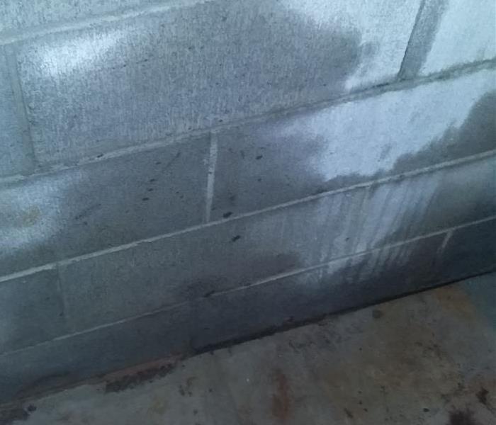 A stone basement wall with water stains.