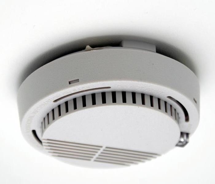 A white smoke detector on the ceiling.